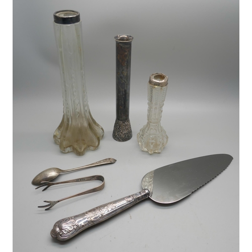 914 - a pair of silver sugar bows, a silver spoon, two silver topped bud vases, a silver handled cake knif... 