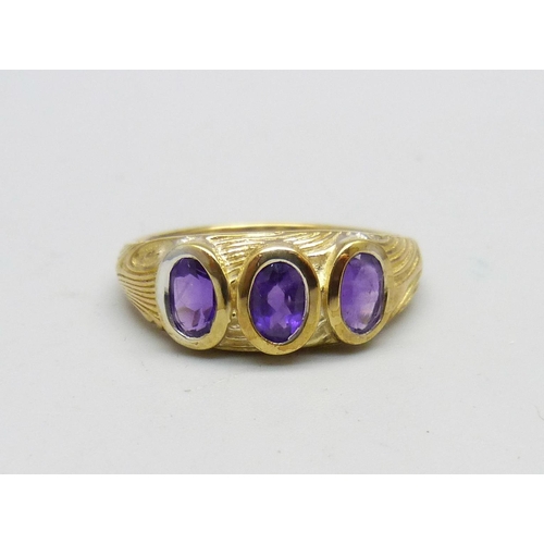 947 - A silver gilt, amethyst three stone ring, T/U