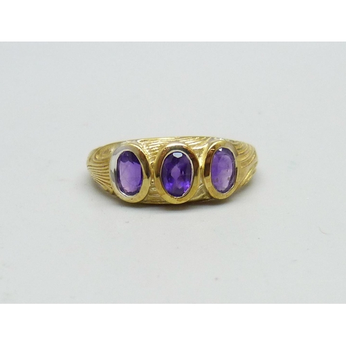 947 - A silver gilt, amethyst three stone ring, T/U