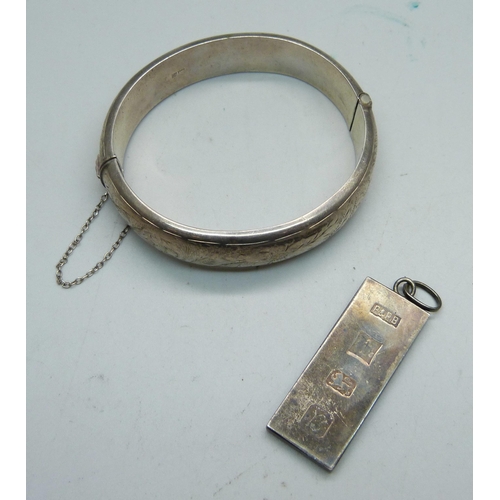 974 - A silver bangle, Birmingham 1964, and a silver ingot pendant, 56g