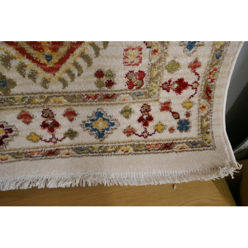 1343 - A cream ground all over diamond design rug, 170 x 120cm