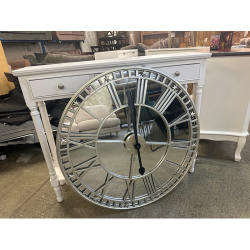 1536 - A white three drawer console table and a mirrored wall clock the mirror have a crack in the centre