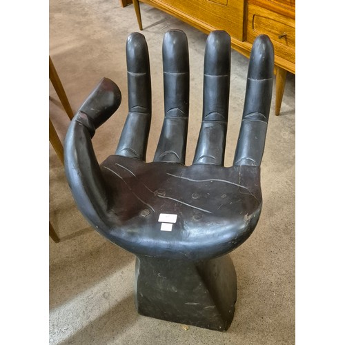 67 - An ebonised hand shaped stool