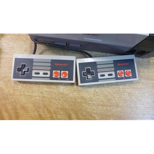 2119 - A Nintendo Entertainment System, NES version, two NES controllers, cables, a Game Genie video game e... 