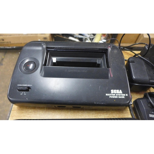 2124 - Two Sega Master System II power base consoles, with power cables, two Sega arcade Control joysticks ... 