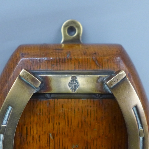 642 - A Victorian oak and brass horseshoe paper clip