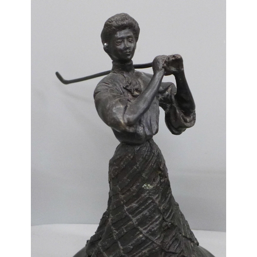 671 - A bronze figure of a female Victorian golfer, a brass and a resin figure of a golfer, two golfing pl... 