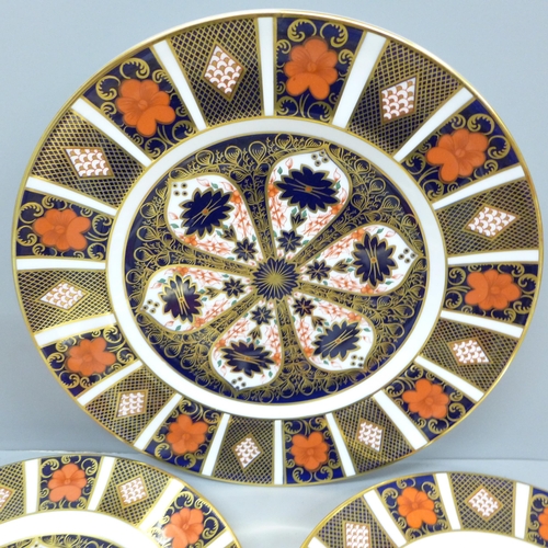 715 - A Royal Crown Derby 1128 pattern dinner plate, second, two side plates and two pin dishes