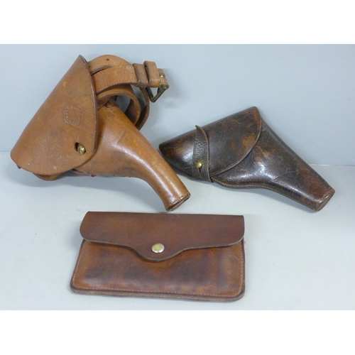 756 - Two leather pistol cases/holsters and a leather cartridge case