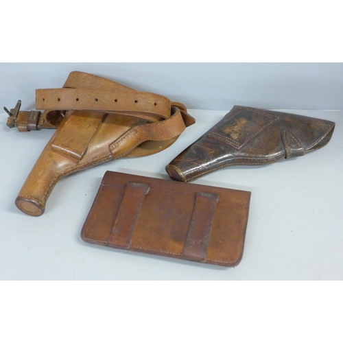 756 - Two leather pistol cases/holsters and a leather cartridge case