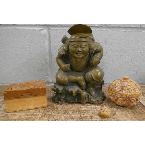 831 - Oriental items including cast pressed stone Chinese figure holding a fish, 23cms, a Chinese wooden p... 