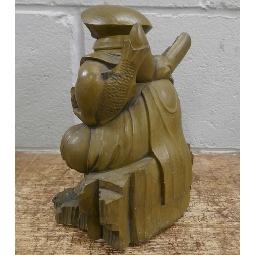 831 - Oriental items including cast pressed stone Chinese figure holding a fish, 23cms, a Chinese wooden p... 