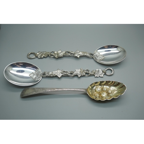 865 - A George III silver berry spoon, London 1782, 65g, and two vine detail serving spoons