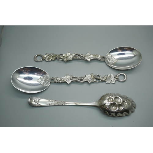 865 - A George III silver berry spoon, London 1782, 65g, and two vine detail serving spoons