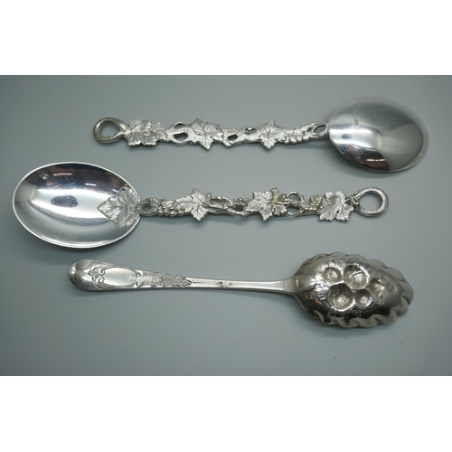 865 - A George III silver berry spoon, London 1782, 65g, and two vine detail serving spoons