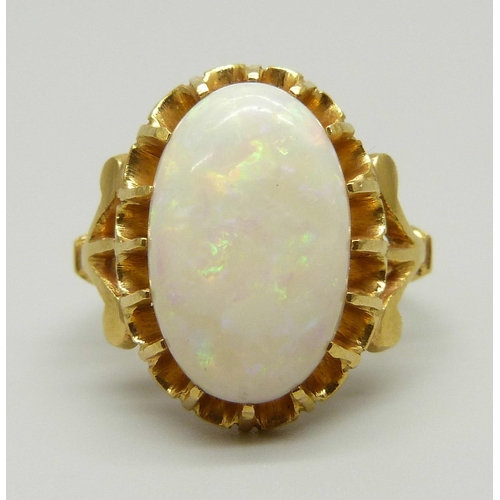 963 - A yellow metal ring set with a large Australian opal, setting tests as 22ct gold, 5.5g, J