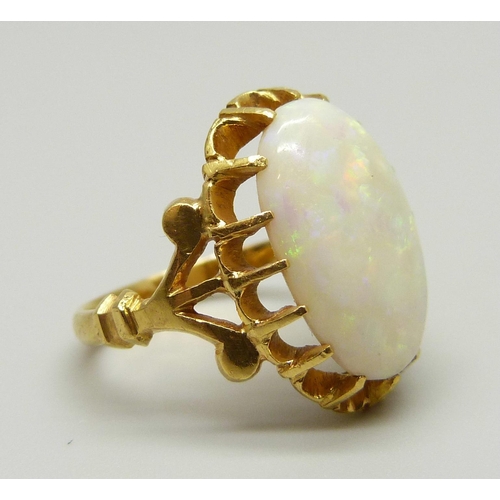 963 - A yellow metal ring set with a large Australian opal, setting tests as 22ct gold, 5.5g, J