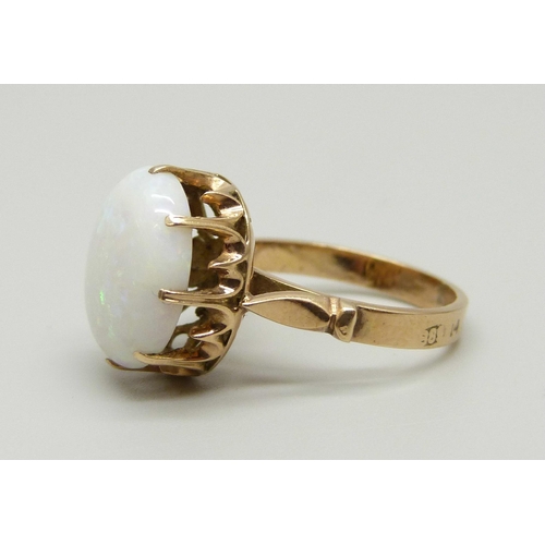 968 - A yellow metal ring set with an opal in a claw setting, tests as gold, marked 14 on the outside of t... 