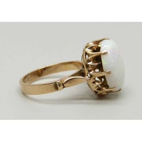 968 - A yellow metal ring set with an opal in a claw setting, tests as gold, marked 14 on the outside of t... 