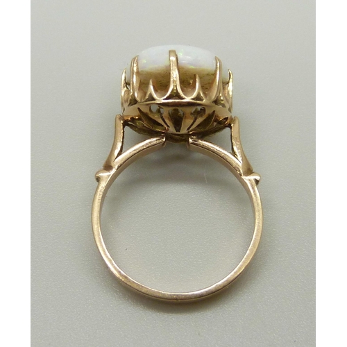 968 - A yellow metal ring set with an opal in a claw setting, tests as gold, marked 14 on the outside of t... 