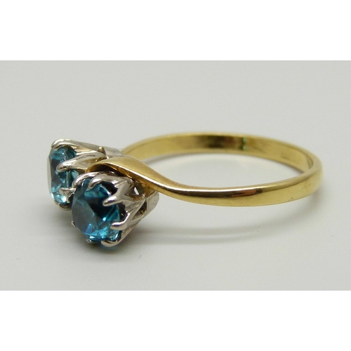 970 - An 18ct gold ring set with two blue zircon stones in a crossover design, 3.5g, Q