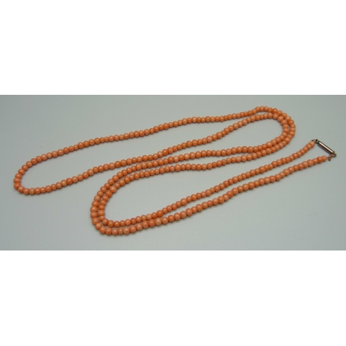 975 - A long coral bead necklace, 32.5g, 90cm