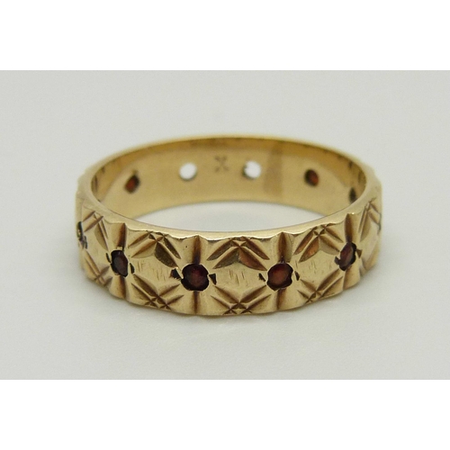 990 - A 9ct gold and garnet eternity ring, three stones missing, 3.3g, P