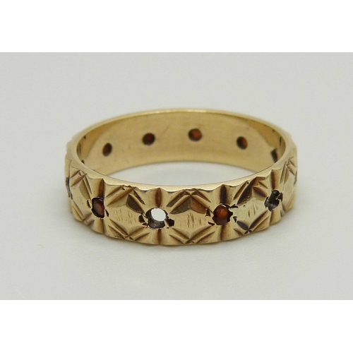 990 - A 9ct gold and garnet eternity ring, three stones missing, 3.3g, P