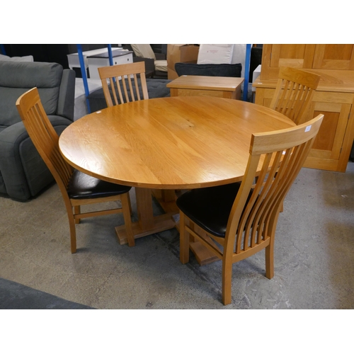 1528 - A circular oak dining table and four chairs