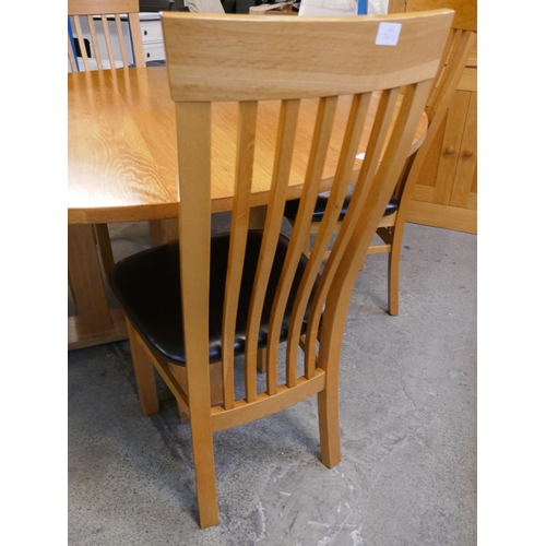 1528 - A circular oak dining table and four chairs