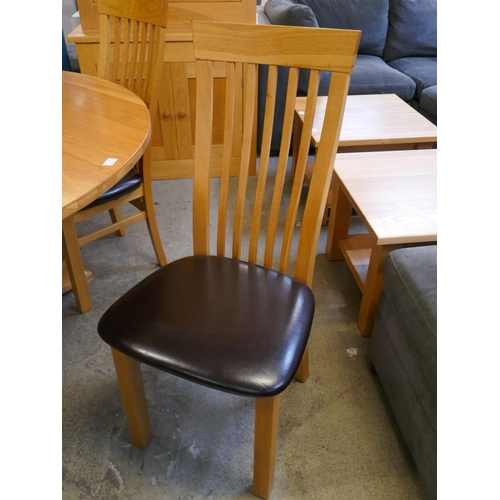 1528 - A circular oak dining table and four chairs