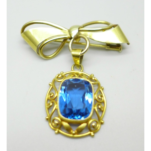 1003 - An 18ct gold pendant set with a blue stone, on a yellow metal brooch mount in the form of a bow, 6.7... 