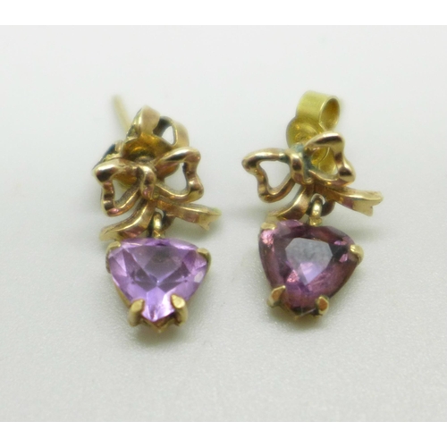 1012 - A pair of yellow metal earrings with bow detail, set with amethyst heart shape stones, 2.1g