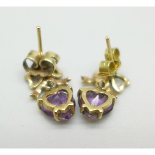 1012 - A pair of yellow metal earrings with bow detail, set with amethyst heart shape stones, 2.1g