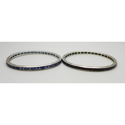 1038 - Two white metal bangles set with blue glass stones