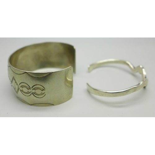 1054 - A Navajo style bangle with bear and feather decoration, marked C Sterling, 34g, and silver bangle in... 