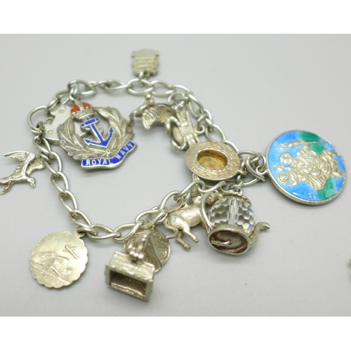 1066 - A silver charm bracelet with silver and white metal charms, 50g