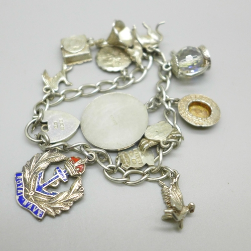 1066 - A silver charm bracelet with silver and white metal charms, 50g