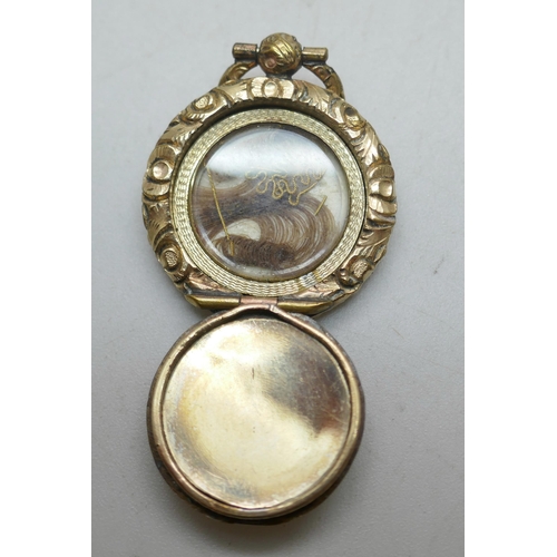 1118 - A small Georgian gold toned mourning brooch, an early Victorian gold toned memorial locket pendant w... 