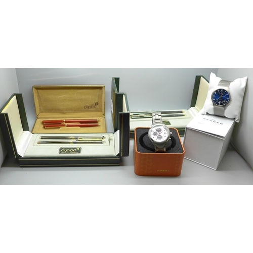 607 - Two wristwatches, Skagen and Fossil and three Elysee pen sets
