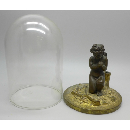 616 - A small bronze figure of a cherub at prayer under an associated glass dome