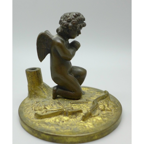 616 - A small bronze figure of a cherub at prayer under an associated glass dome