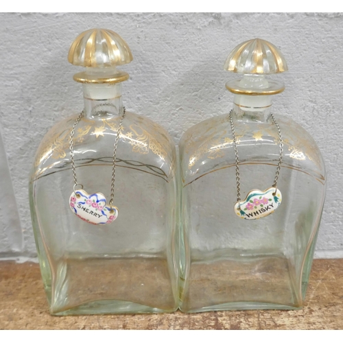 717 - A pair of 19th Century glass decanters with gilded decoration to the shoulders, neck and top, each w... 