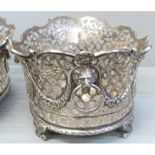 753 - A pair of Victorian pierced silver baskets with lion head ring handles and ram and swags details, ea... 