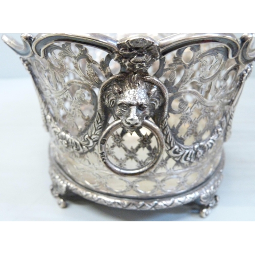 753 - A pair of Victorian pierced silver baskets with lion head ring handles and ram and swags details, ea... 