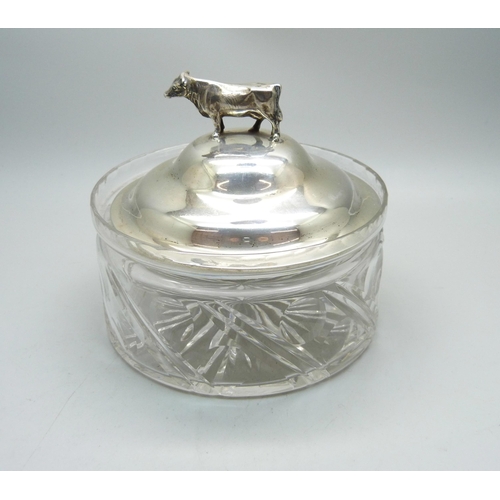 766 - A silver topped glass dish with bull detail, top 83g