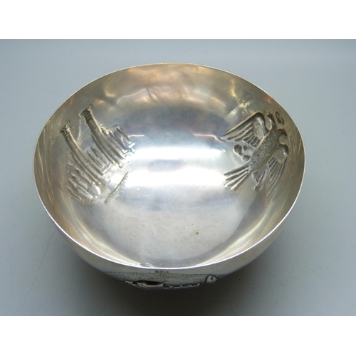 782 - An 830 silver bowl on three feet and with three circular panels with double headed eagle, Corinthian... 