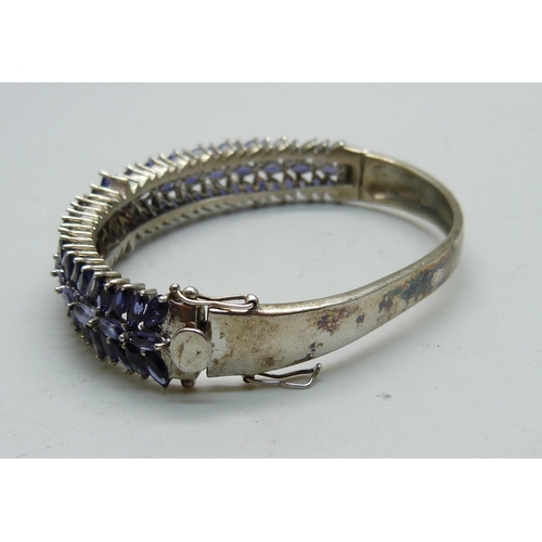 836 - A silver bangle set with purple stones, a/f dented and split, 25g