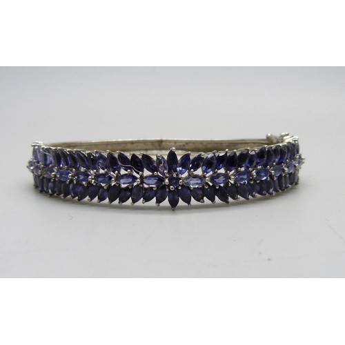 836 - A silver bangle set with purple stones, a/f dented and split, 25g