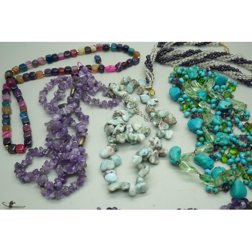 848 - A turquoise seven strand necklace with silver clasp, two amethyst necklaces, one with earrings, a mu... 